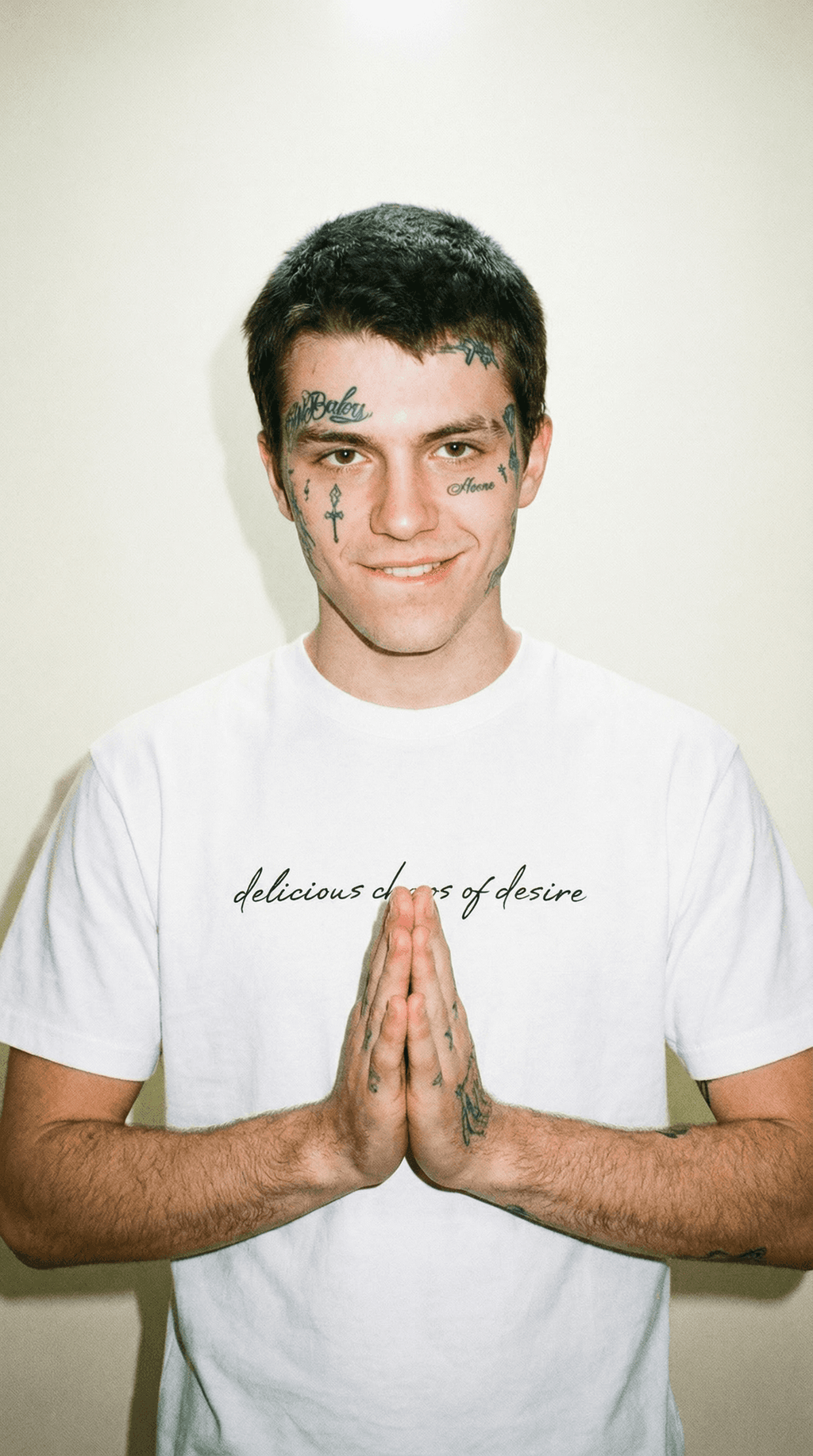Male model wearing a white chaos of desire oversized t-shirt with black script text on front