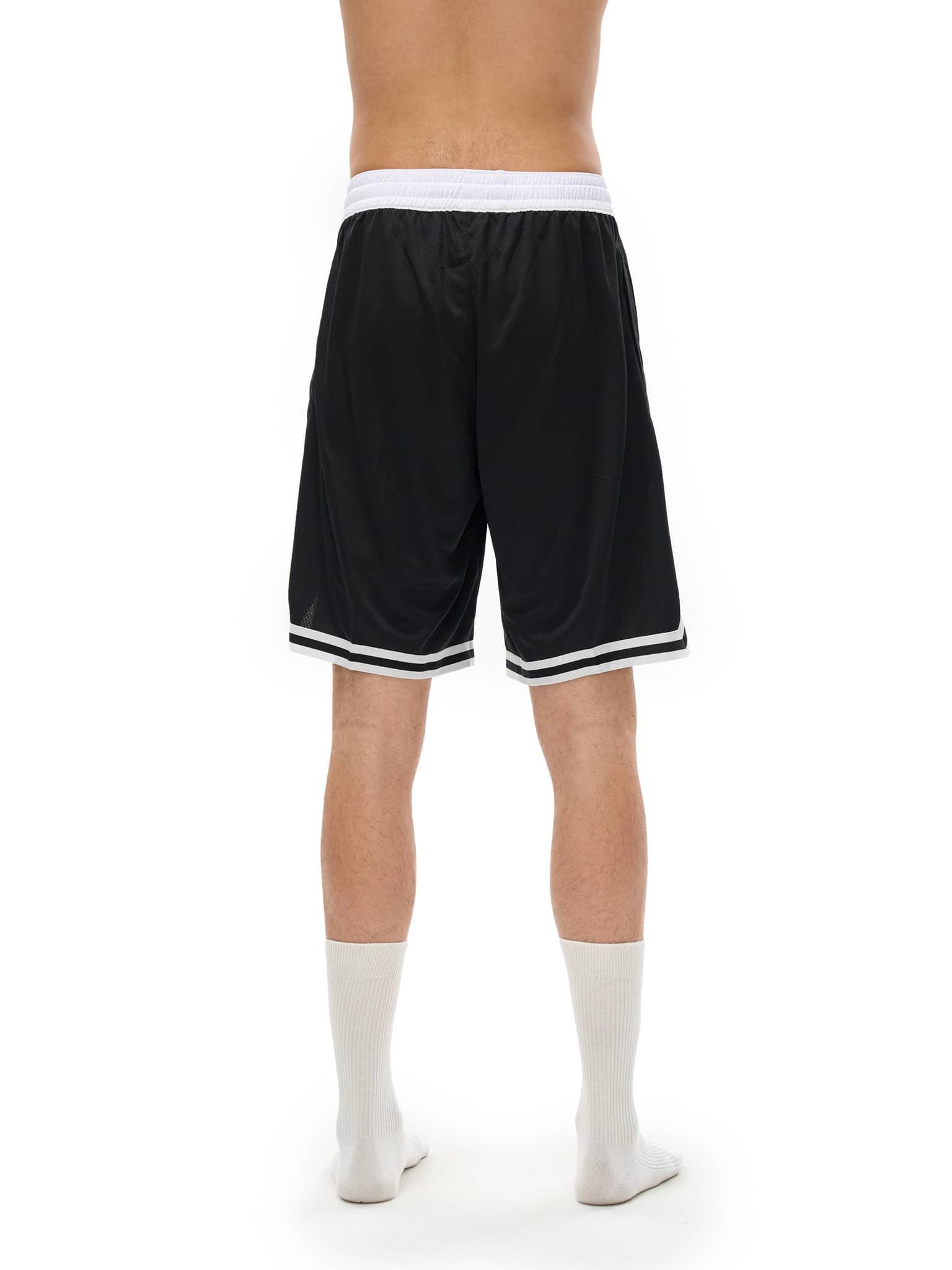 Back view of classic basketball shorts in black with white waistband and trim on a male model