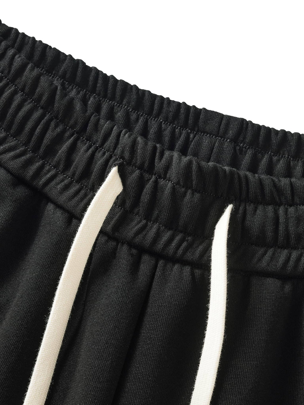 Close-up of black contrast side-stripe straight-leg pants elastic waistband with white drawstrings