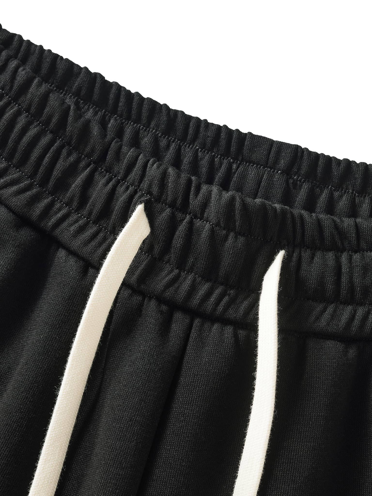 Close-up of black contrast side-stripe straight-leg pants elastic waistband with white drawstrings
