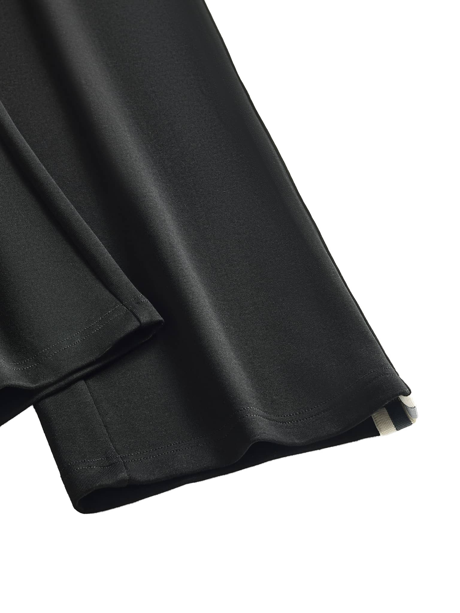 Close-up of FETISHISTO contrast side-stripe straight-leg pants showing black fabric with white side stripe detail