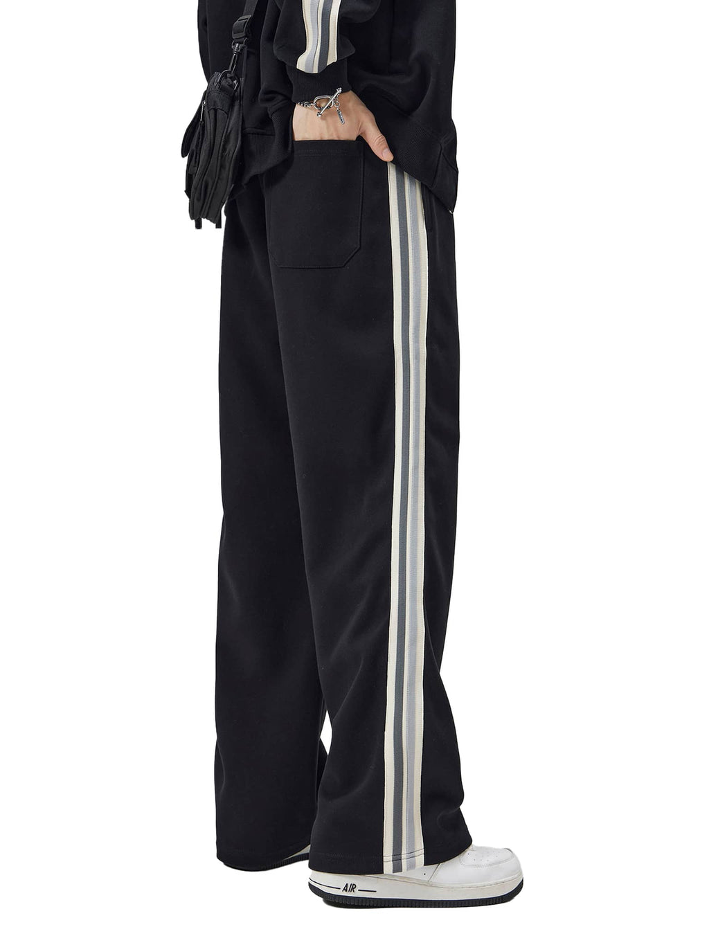 FETISHISTO contrast side-stripe straight-leg pants in black with white stripes worn with white sneakers