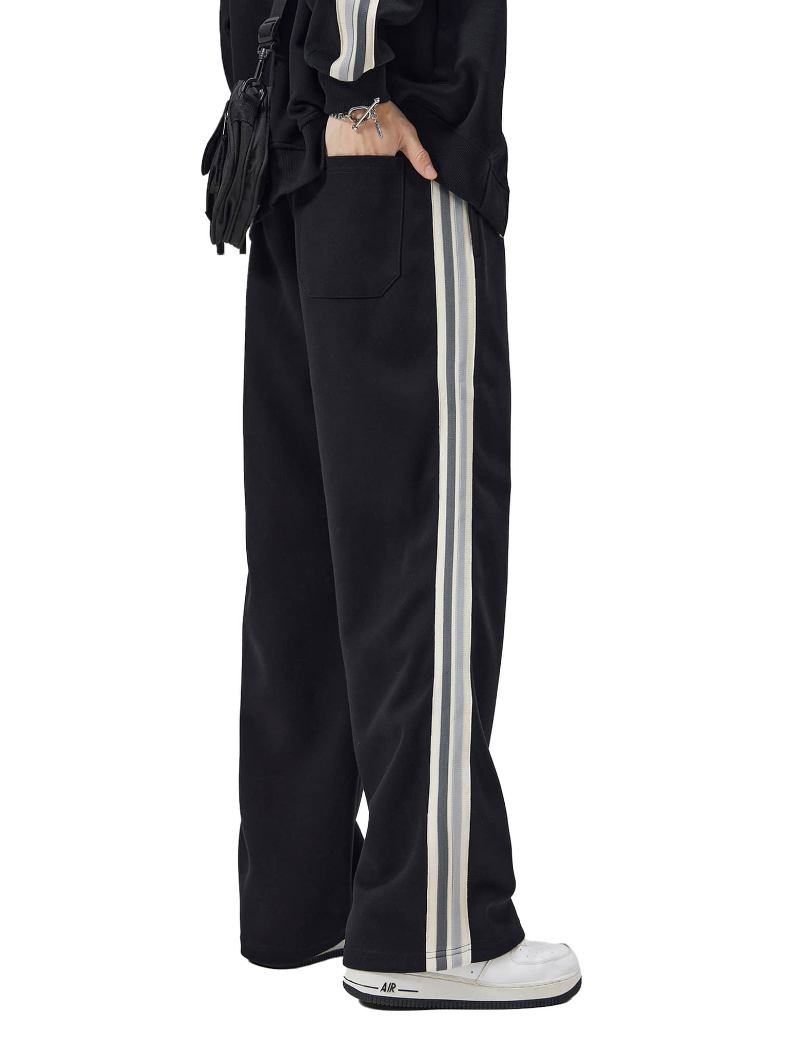 FETISHISTO contrast side-stripe straight-leg pants in black with white stripes worn with white sneakers
