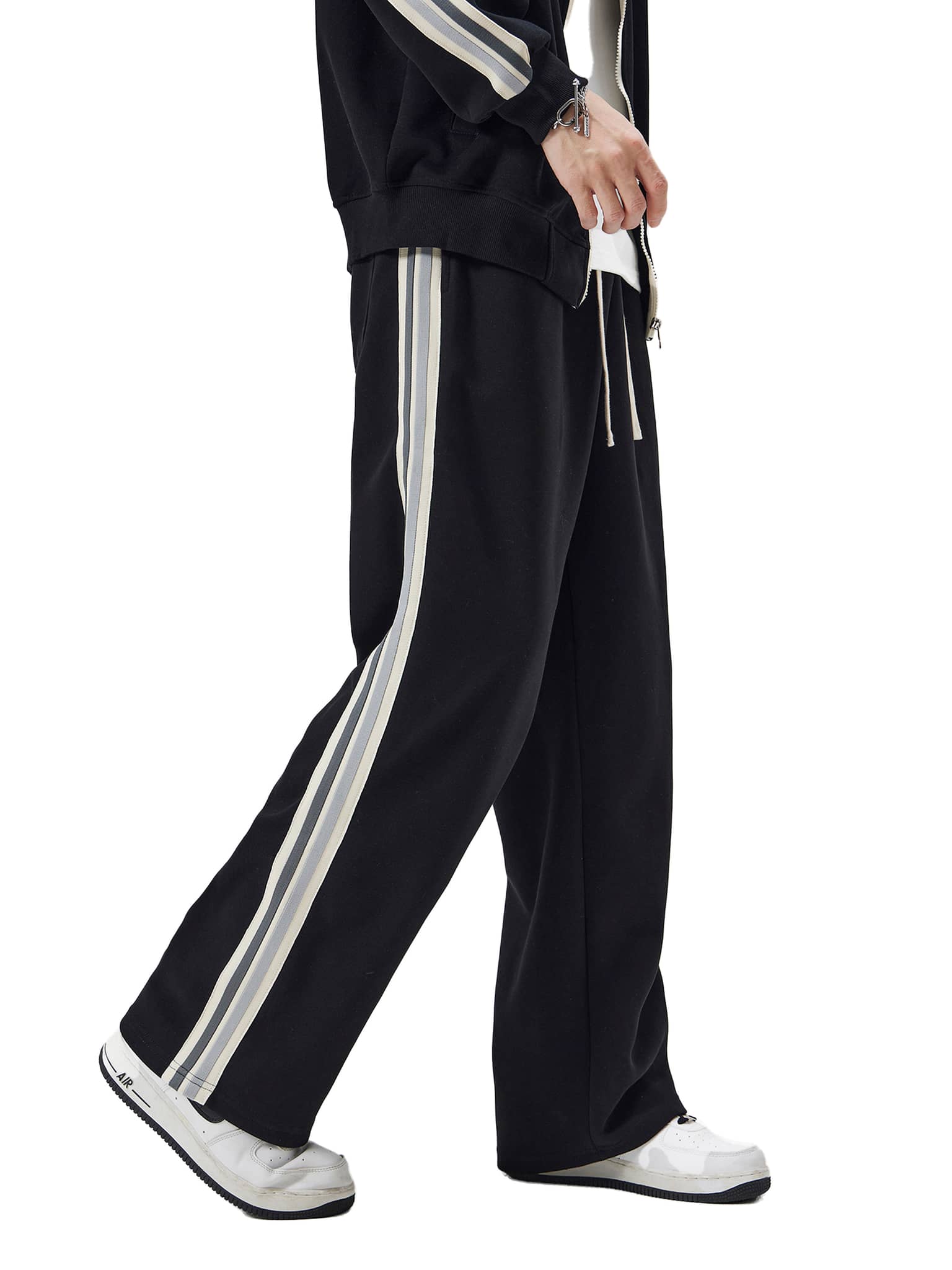Black contrast side-stripe straight-leg pants with white and gray stripes worn with white sneakers