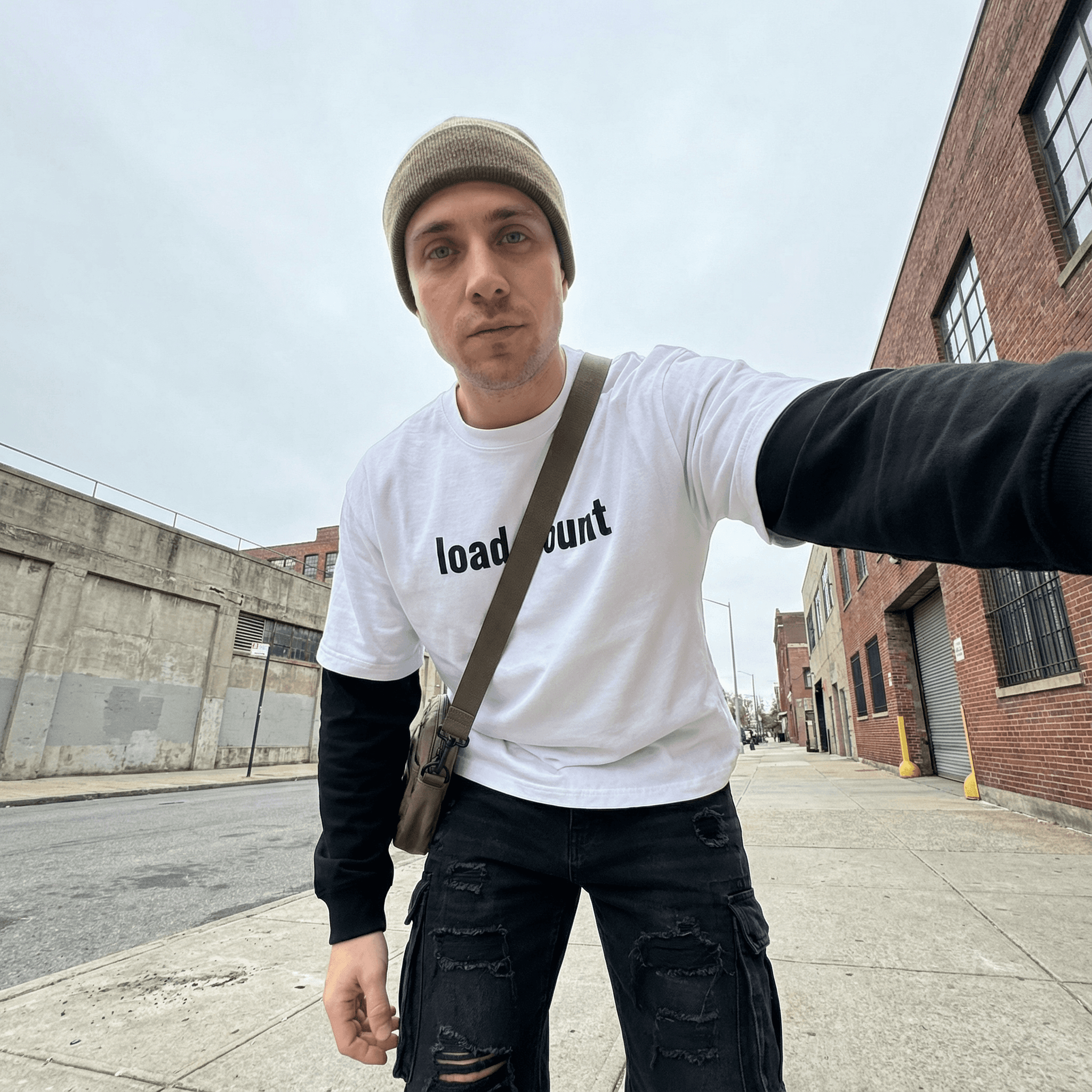 Man wearing FETISHISTO layered contrast sleeve t-shirt white with black sleeves on urban street