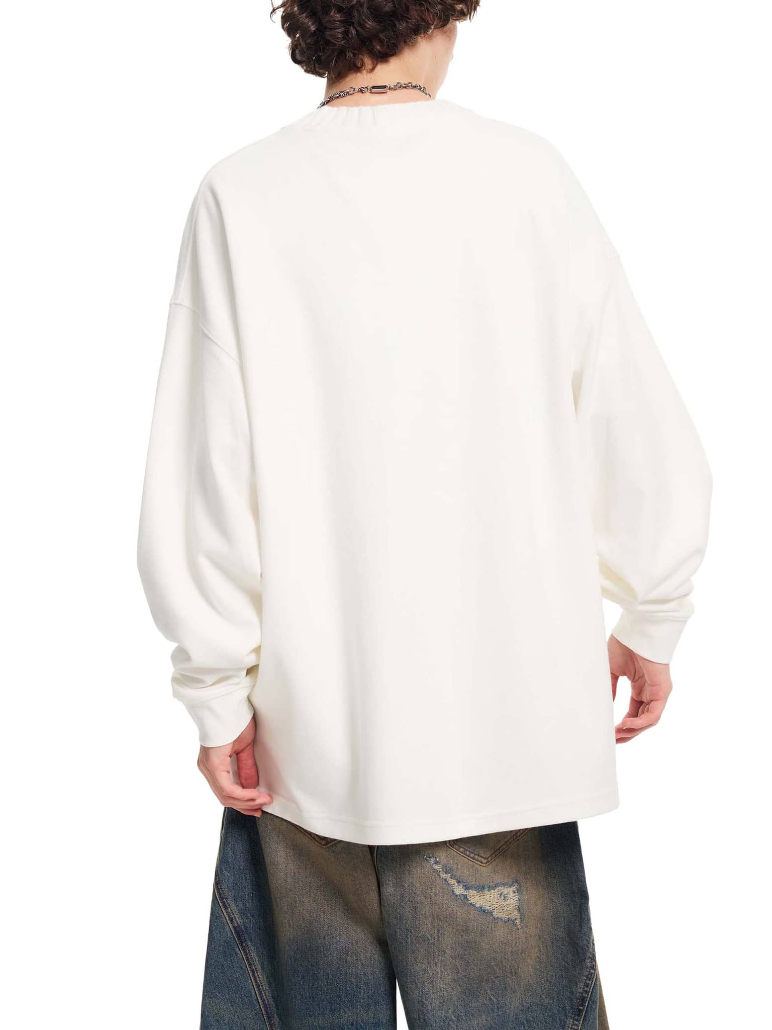 Back view of a person wearing a white oversize knitted round neck sweatshirt with long sleeves