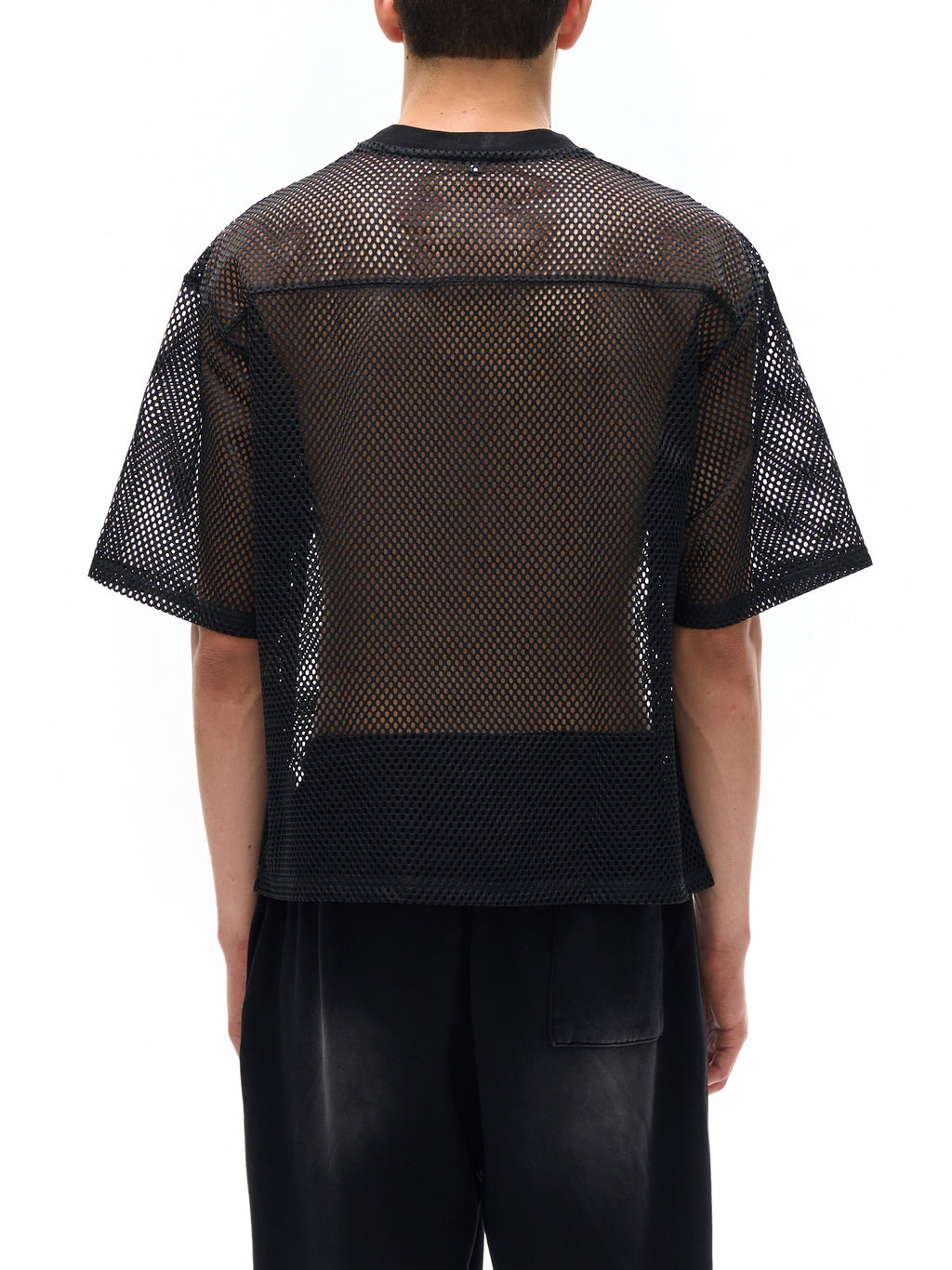 Back view of person wearing black see-through mesh t-shirt by ODMPOD with short sleeves