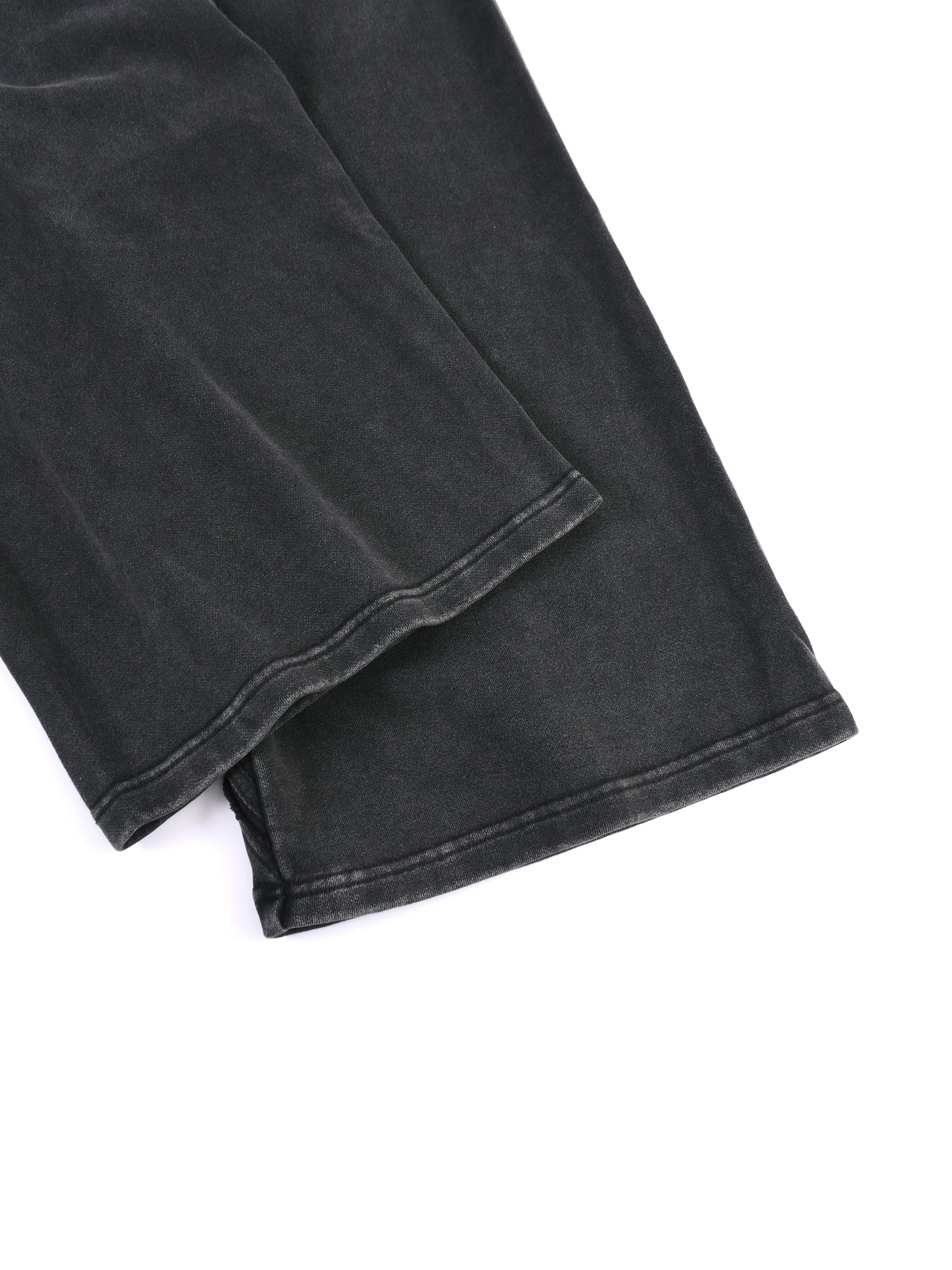 Close-up of black snow washed sweatpants for men showing fabric texture and hem details