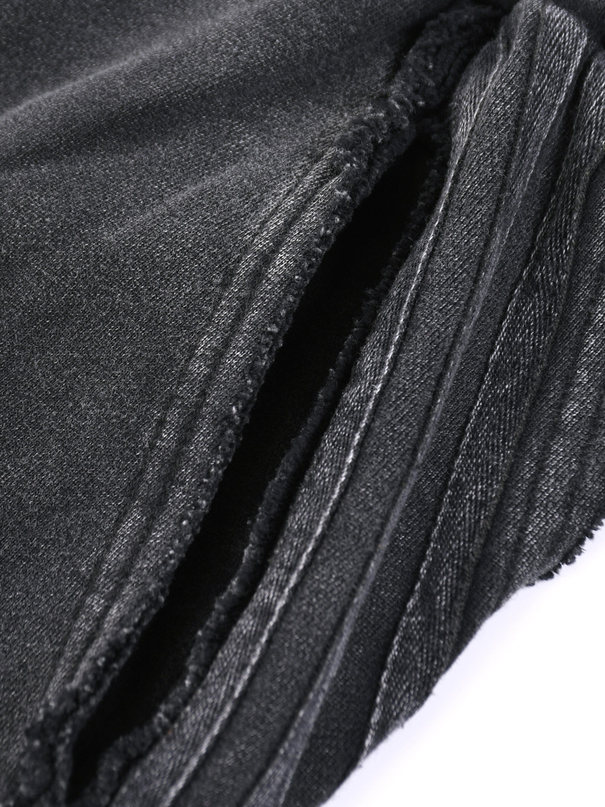 Close-up detail of black snow washed sweatpants for men showing fabric texture and stitching by FETISHISTO