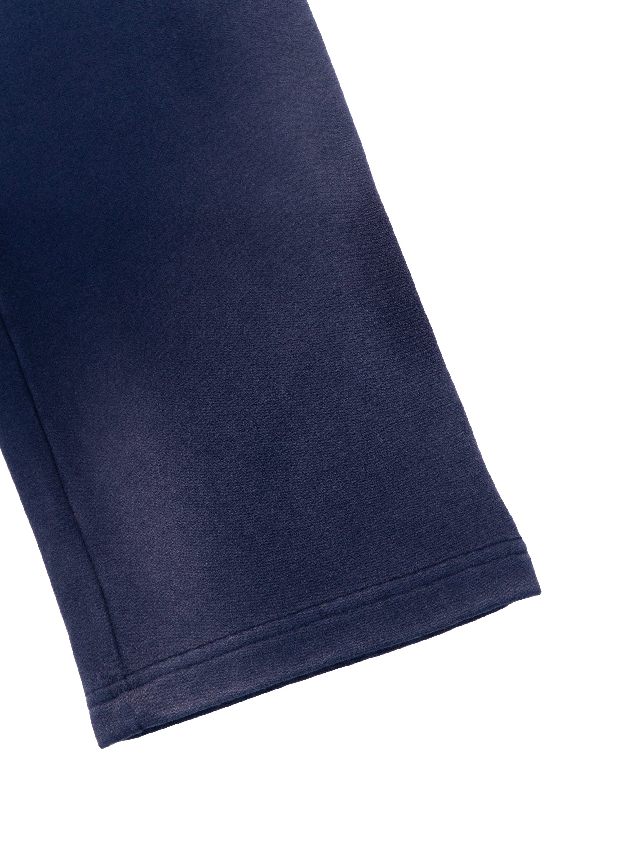 Close-up of navy sun fade straight leg sweatpants hem by FETISHISTO showing fabric texture and stitching