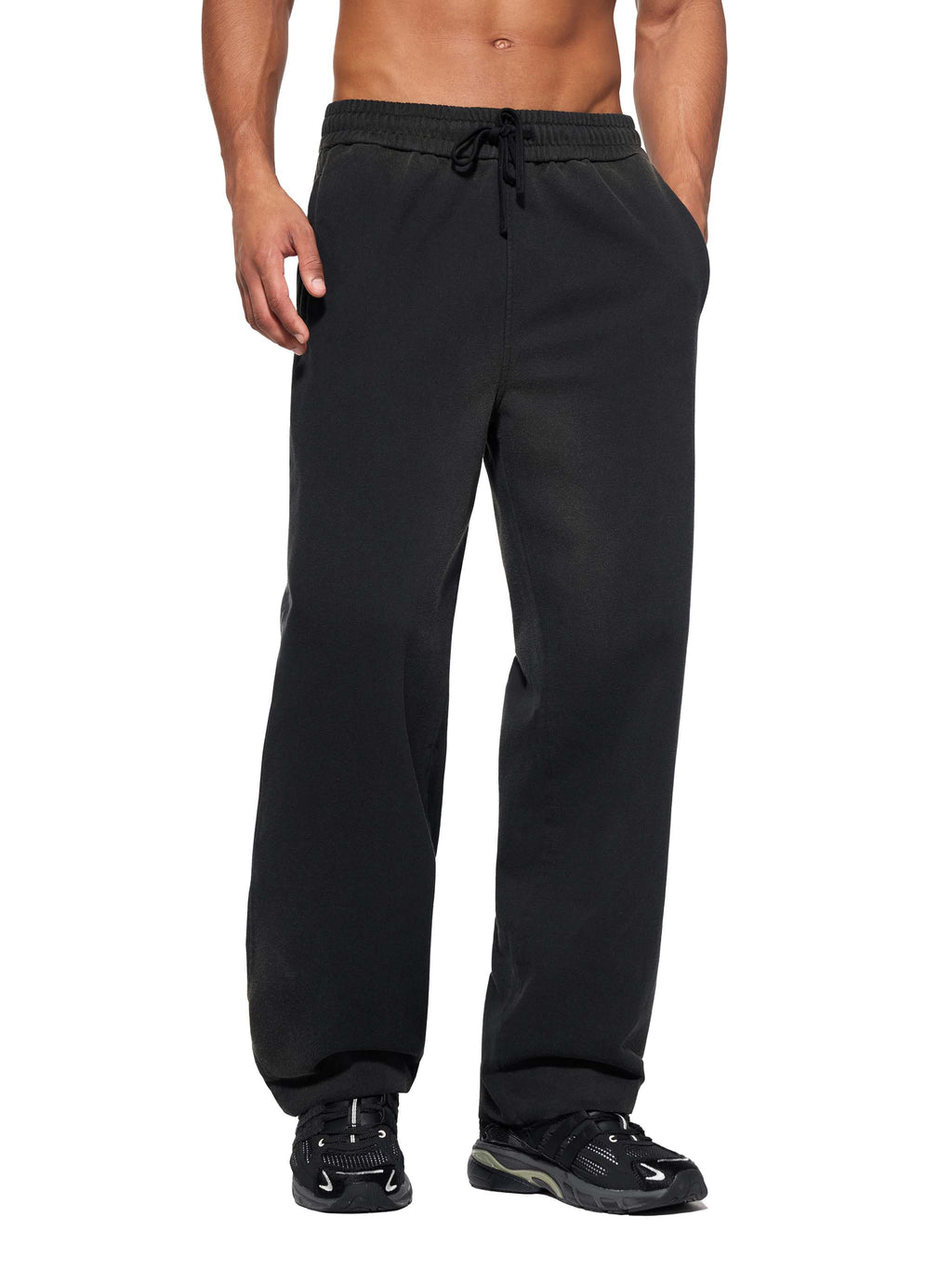 Men wearing black sun fade straight leg sweatpants with drawstring waist and black sneakers