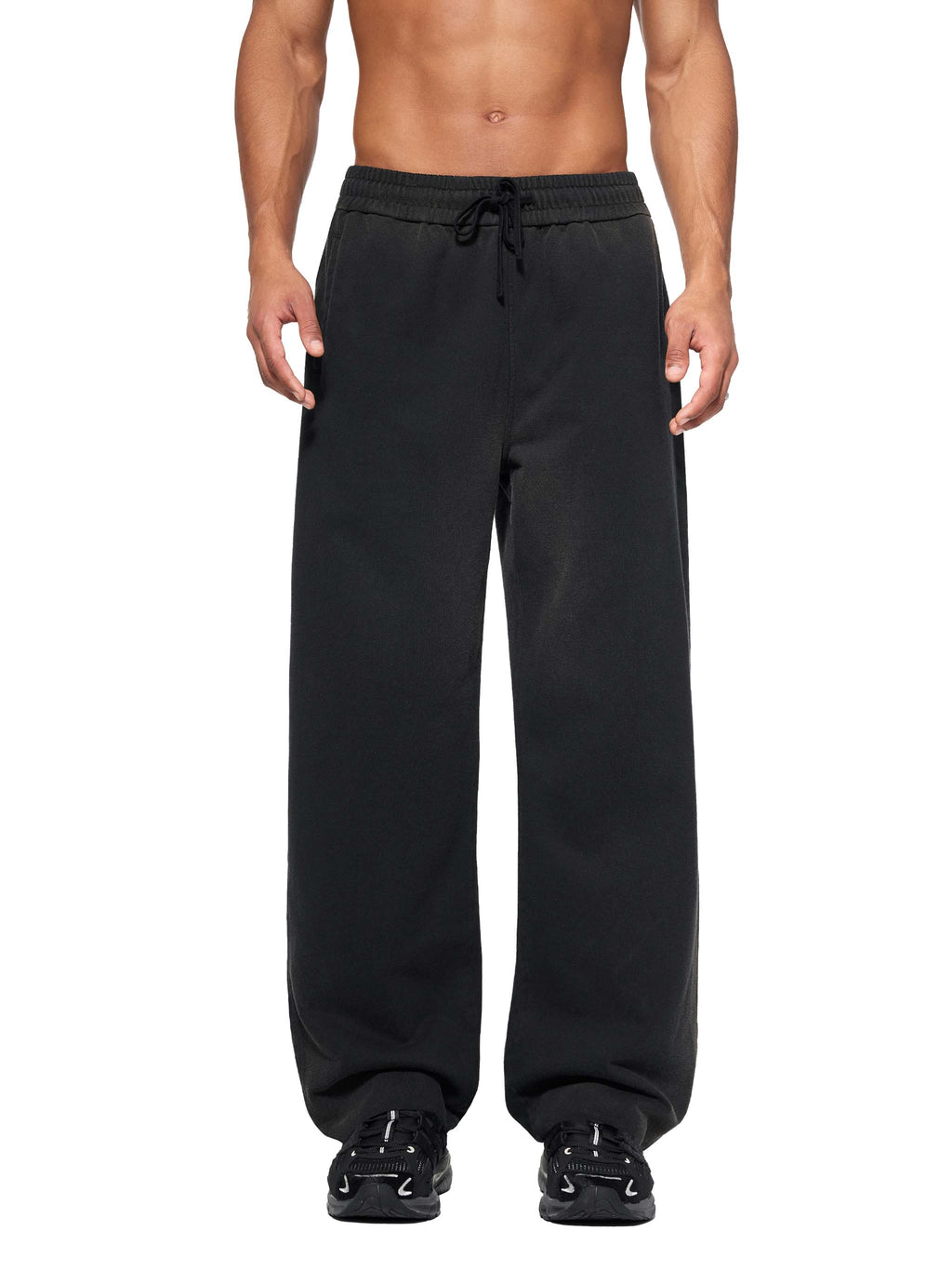 FETISHISTO sun fade straight leg sweatpants in black with drawstring waist worn by male model