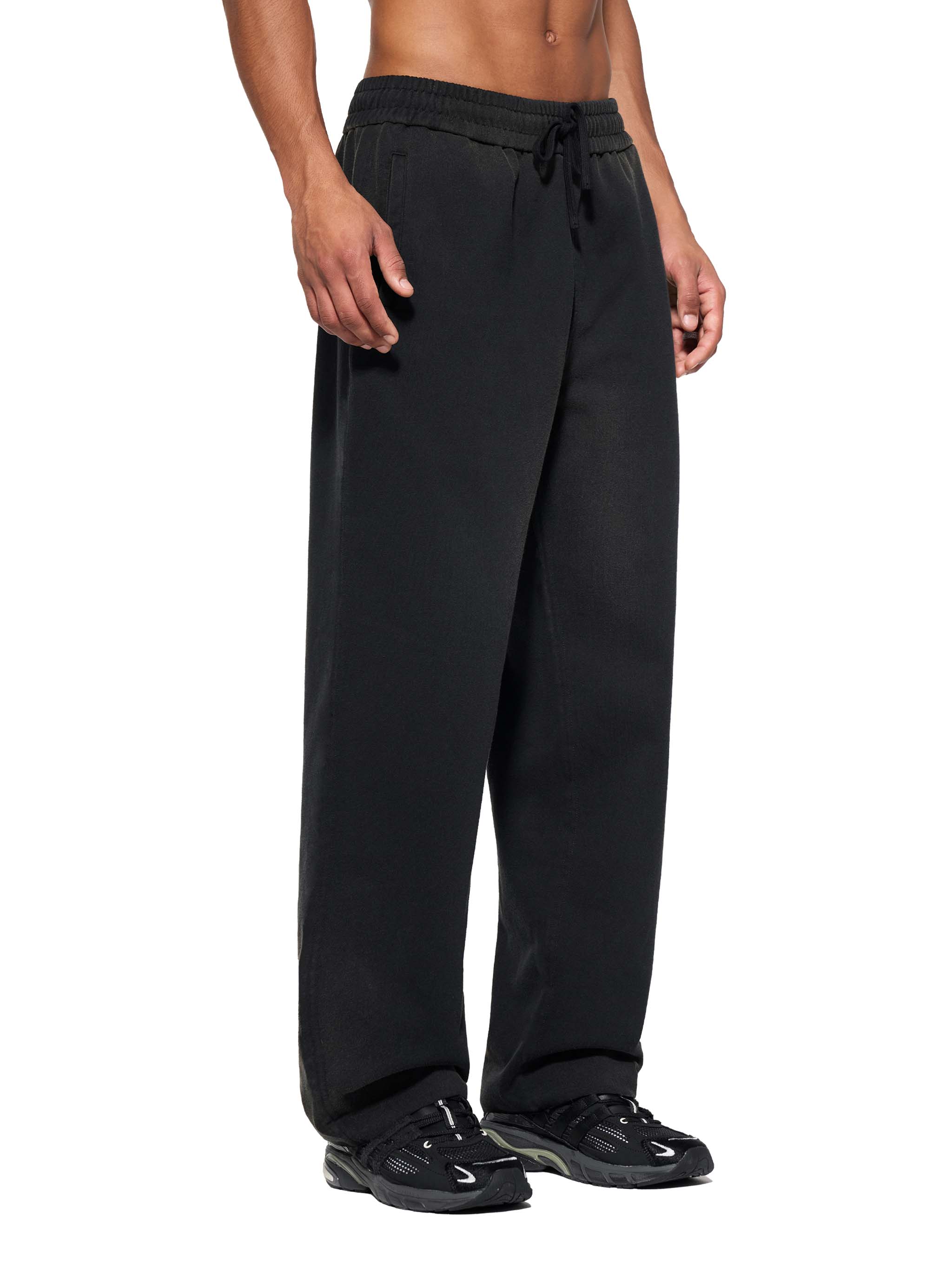 FETISHISTO sun fade straight leg sweatpants in black with drawstring waist worn by male model