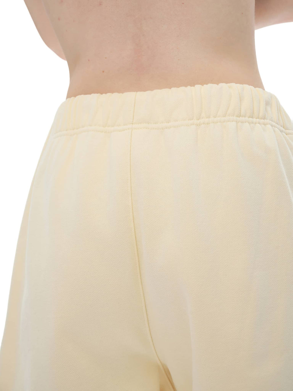 Back view of FETISHISTO cream unisex heavyweight fleece shorts with elastic waistband